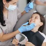 a little girl is getting dental treatment